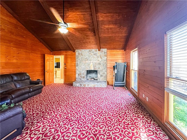 carpeted living room with vaulted ceiling with beams, a wealth of natural light, wooden ceiling, and wood walls