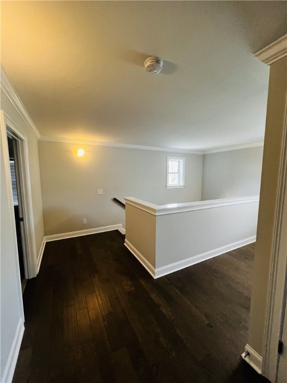 corridor with dark hardwood / wood-style floors and ornamental molding