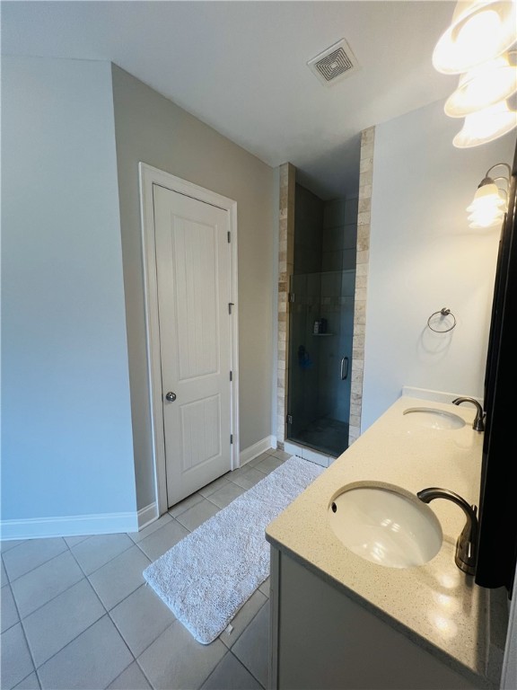 bathroom with tile patterned floors, vanity, and an enclosed shower