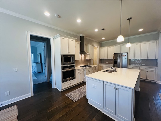 kitchen with hanging light fixtures, decorative backsplash, an island with sink, appliances with stainless steel finishes, and white cabinetry