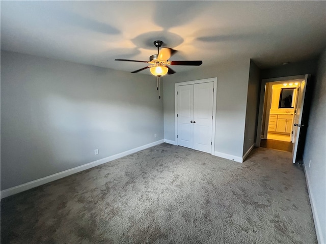 unfurnished bedroom featuring dark colored carpet, a closet, and ceiling fan