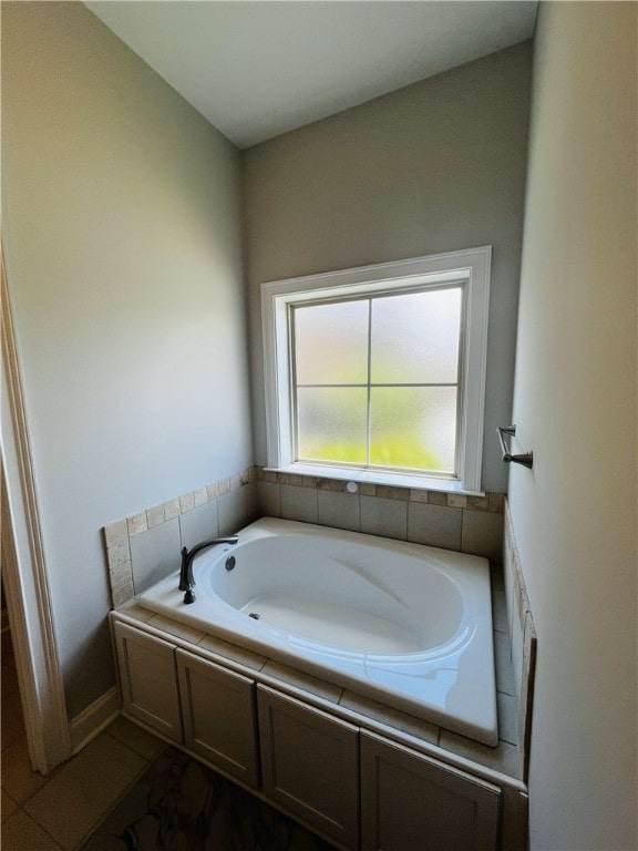 bathroom featuring tile patterned flooring and a relaxing tiled tub