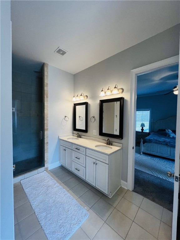 bathroom with tile patterned flooring, vanity, and a shower with door