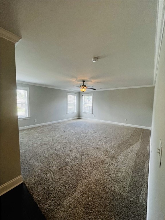 carpeted empty room with plenty of natural light, crown molding, and ceiling fan