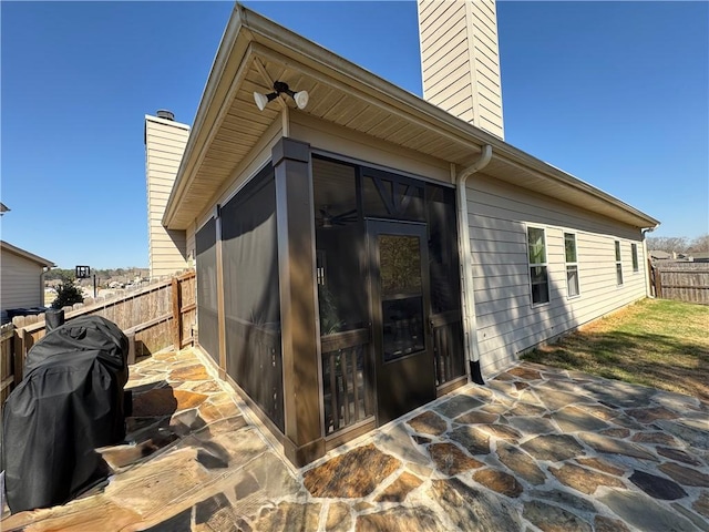 view of outbuilding with a fenced backyard and a sunroom