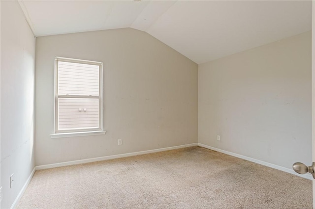 carpeted empty room with lofted ceiling and baseboards