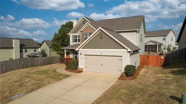 view of front of home with driveway, a chimney, fence, a front lawn, and board and batten siding