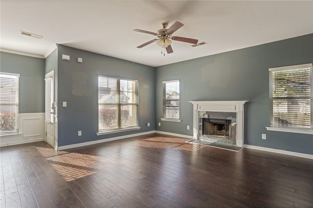 unfurnished living room with a ceiling fan, visible vents, a fireplace, and wood finished floors