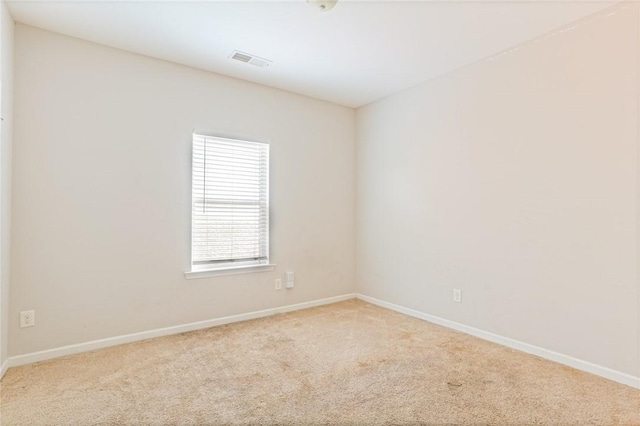 empty room with carpet flooring, visible vents, and baseboards