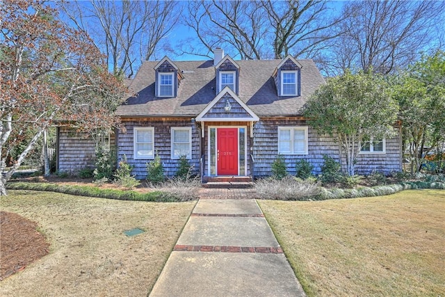 view of front of property with a shingled roof and a front lawn