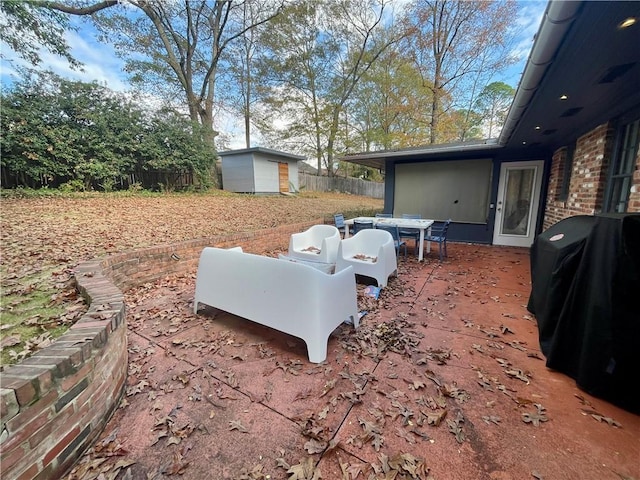 view of yard with a patio, an outdoor structure, a storage unit, and fence