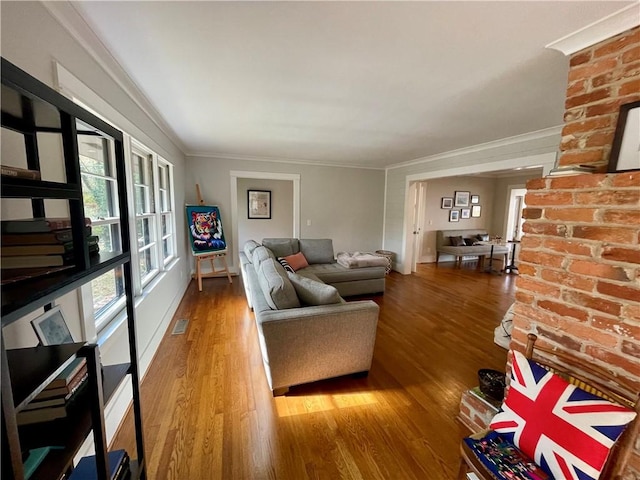 living area featuring crown molding, visible vents, and wood finished floors