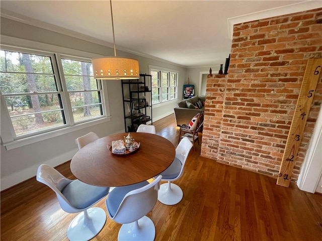 dining room featuring crown molding, baseboards, and wood finished floors