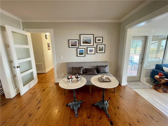 sitting room featuring visible vents, ornamental molding, and wood finished floors