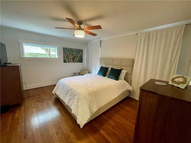 bedroom with crown molding, dark wood finished floors, baseboards, and ceiling fan