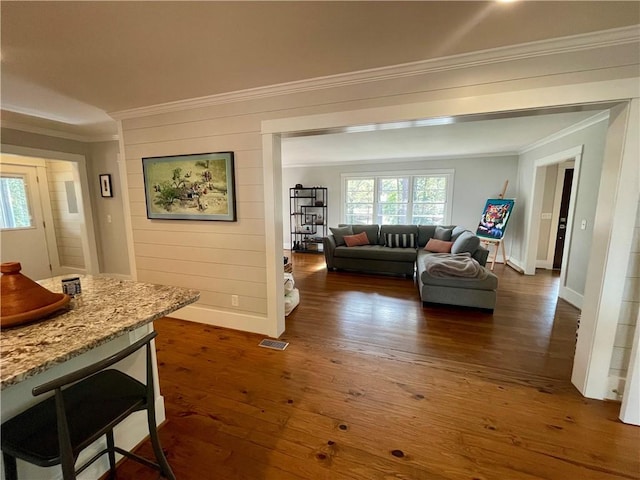 living room featuring dark wood finished floors, visible vents, crown molding, and baseboards