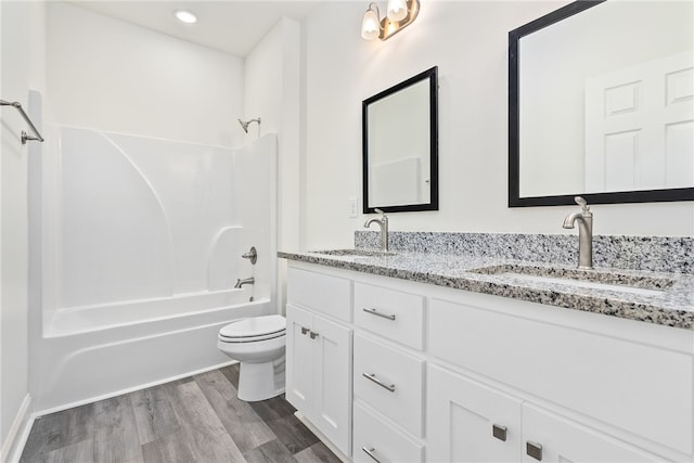 full bathroom featuring vanity, wood-type flooring,  shower combination, and toilet