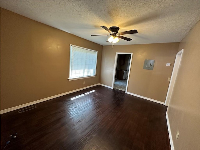 empty room with a textured ceiling, dark hardwood / wood-style floors, and ceiling fan