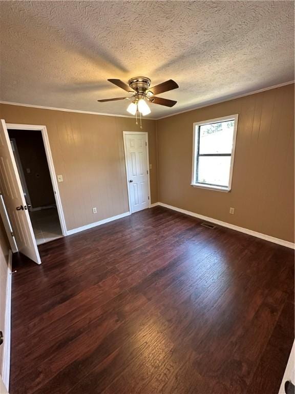 interior space featuring ceiling fan, dark hardwood / wood-style flooring, a textured ceiling, and ornamental molding