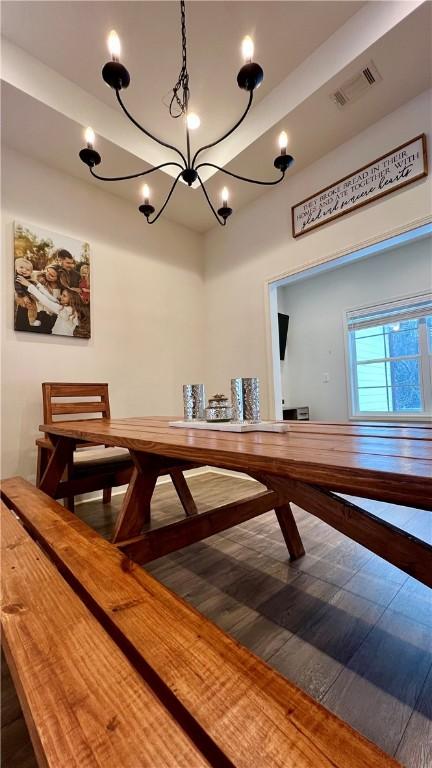 bar with pendant lighting, wood-type flooring, and a notable chandelier