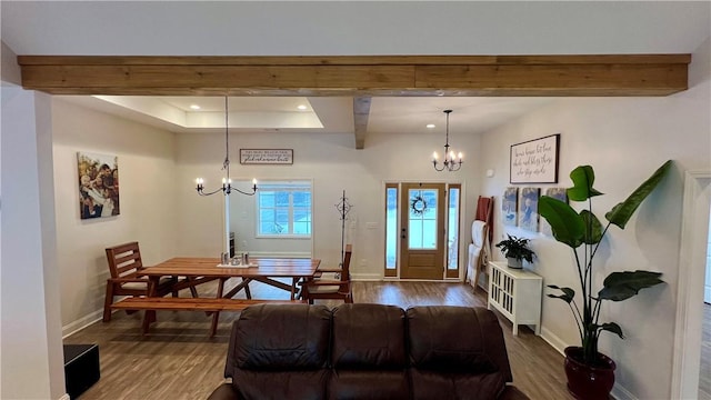 living room featuring an inviting chandelier, wood-type flooring, and beamed ceiling