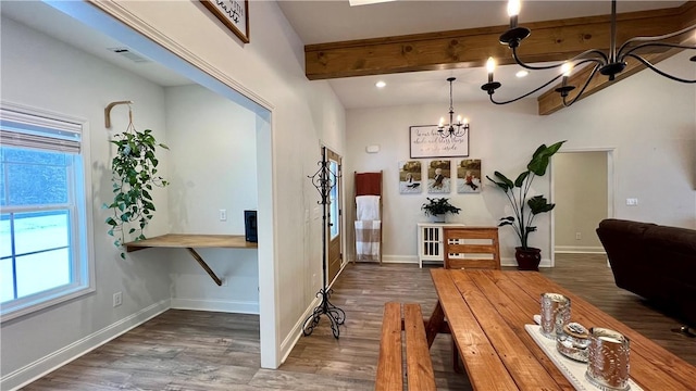 dining space with dark hardwood / wood-style flooring, a notable chandelier, and beam ceiling