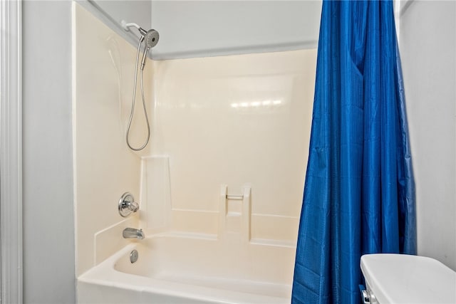 bathroom featuring shower / bath combination with curtain and toilet