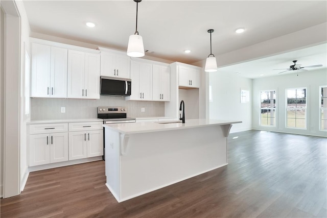 1013 Crossing Ct E, Valley, AL 36854 - kitchen featuring stainless steel appliances, dark wood-style floors, light countertops, a kitchen island with sink, and backsplash