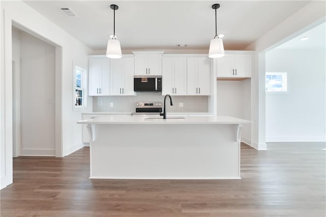 1013 Crossing Ct E, Valley, AL 36854 - kitchen with a kitchen island with sink, light countertops, stainless steel range with electric cooktop, and white cabinetry