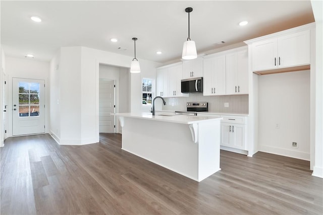 1013 Crossing Ct E, Valley, AL 36854 - kitchen featuring stainless steel appliances, an island with sink, wood finished floors, light countertops, and recessed lighting