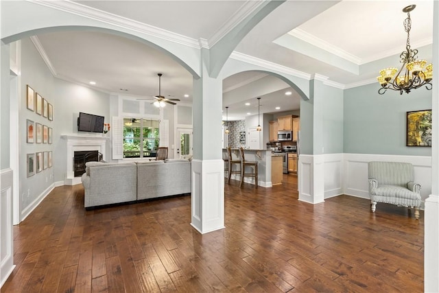 4112 Creekview Ct, Auburn, AL 36832 - living room featuring dark wood-style floors, ceiling fan, a fireplace with raised hearth, ornamental molding, and a chandelier