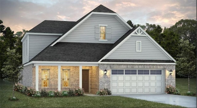 view of front of property featuring a lawn, covered porch, and a garage