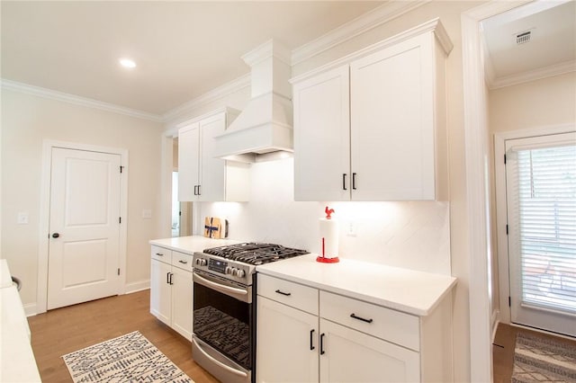 1632 James Burt Pkwy, Auburn, AL 36830 - kitchen with gas range, ornamental molding, light wood-style floors, white cabinetry, and light countertops