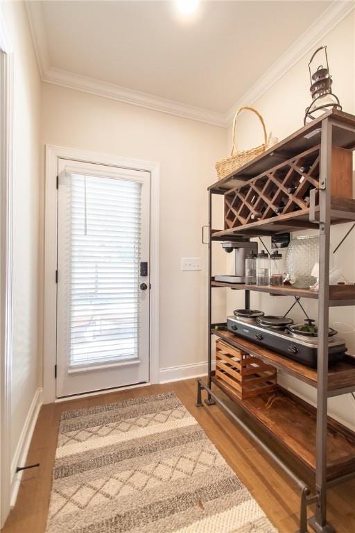 doorway featuring ornamental molding and hardwood / wood-style flooring