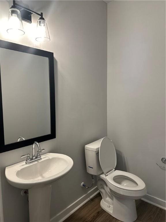 bathroom featuring sink, toilet, and hardwood / wood-style flooring