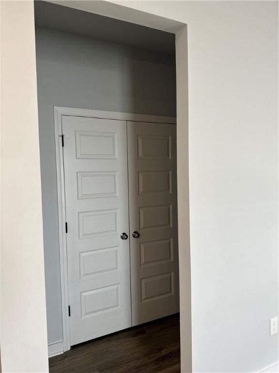 corridor with dark hardwood / wood-style flooring