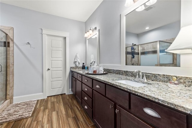 2217 Morgan Dr, Auburn, AL 36830 - full bath with a stall shower, double vanity, wood finished floors, and baseboards