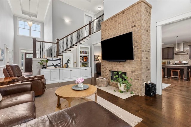 2217 Morgan Dr, Auburn, AL 36830 - living area featuring a towering ceiling, dark wood-style flooring, stairway, a fireplace, and ornamental molding