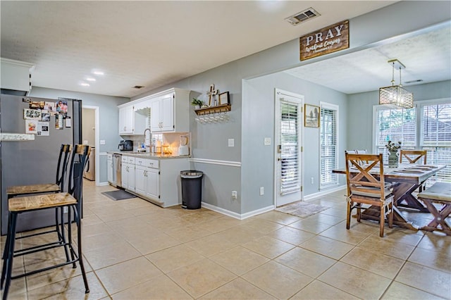 205 Summerbrooke Loop, Phenix City, AL 36870 - kitchen featuring light countertops, light tile patterned floors, white cabinets, stainless steel appliances, and plenty of natural light