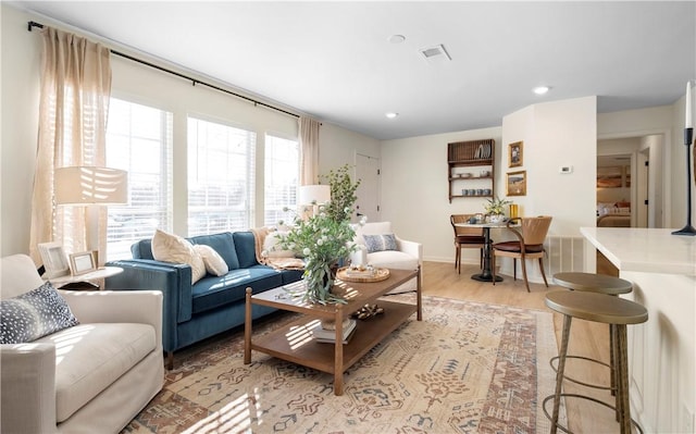 living room featuring recessed lighting, visible vents, and light wood-style flooring