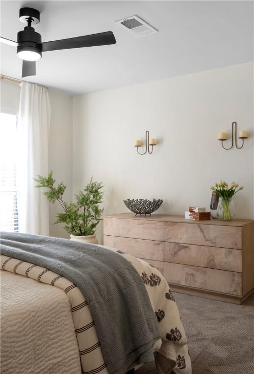 bedroom featuring carpet floors, a ceiling fan, and visible vents