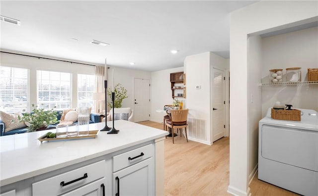 kitchen featuring light countertops, washer / dryer, visible vents, and light wood-type flooring