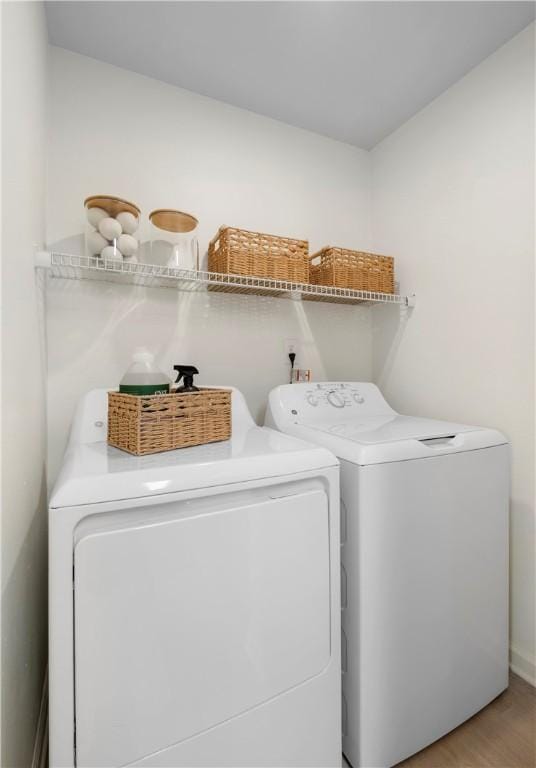 laundry area featuring laundry area, washer and clothes dryer, and light wood-style floors