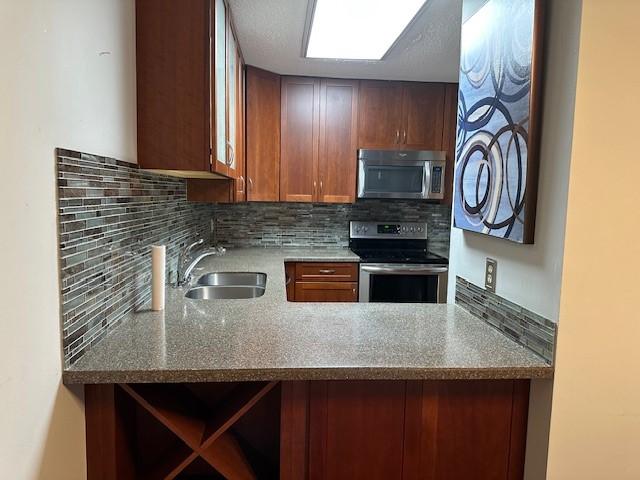 371 E Thach Ave Unit 4, Auburn, AL 36830 - kitchen featuring stainless steel appliances, a sink, tasteful backsplash, stone countertops, and a peninsula