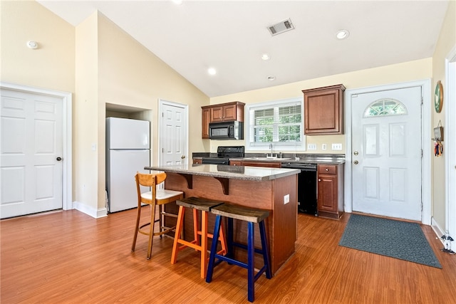 802 W Longleaf Dr Unit 71, Auburn, AL 36832 - kitchen featuring black appliances, a kitchen breakfast bar, a kitchen island, wood finished floors, and a sink