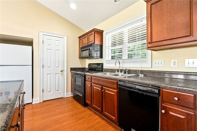 802 W Longleaf Dr Unit 71, Auburn, AL 36832 - kitchen featuring black appliances, dark countertops, vaulted ceiling, a sink, and light wood finished floors