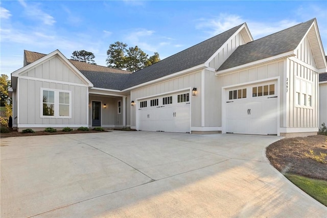 view of front of home with board and batten siding, concrete driveway, roof with shingles, and a garage