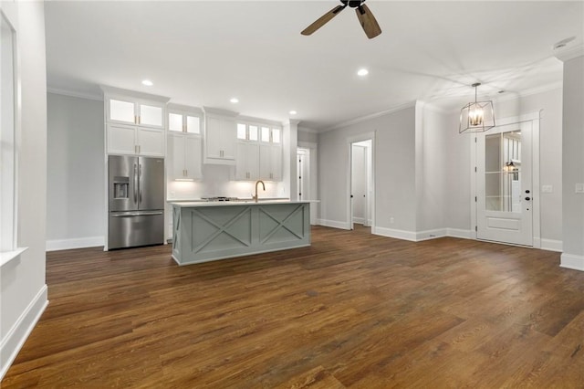 interior space with baseboards, ceiling fan with notable chandelier, dark wood-style floors, ornamental molding, and recessed lighting