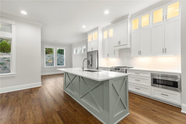 kitchen with a center island with sink, light countertops, ornamental molding, stainless steel appliances, and recessed lighting