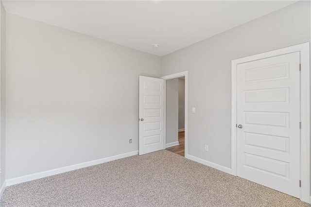 empty room featuring carpet floors and baseboards